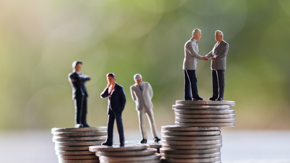 Empresários em miniatura em cima de pilhas de moedas representando o capital social de uma  empresa - efacont